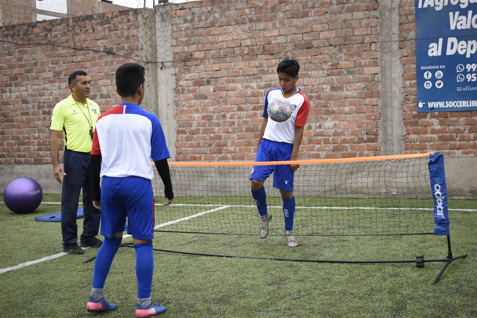 Alumnos jugando fútbol-tenis con red