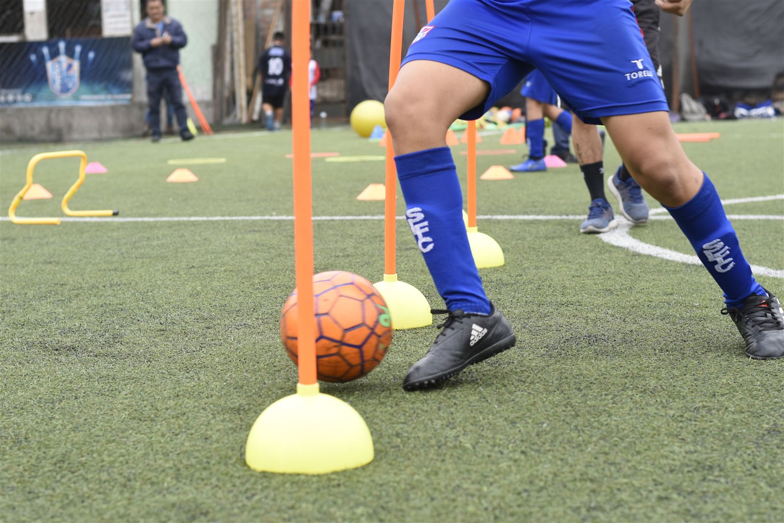 Alumno conduciendo el balón entre conos