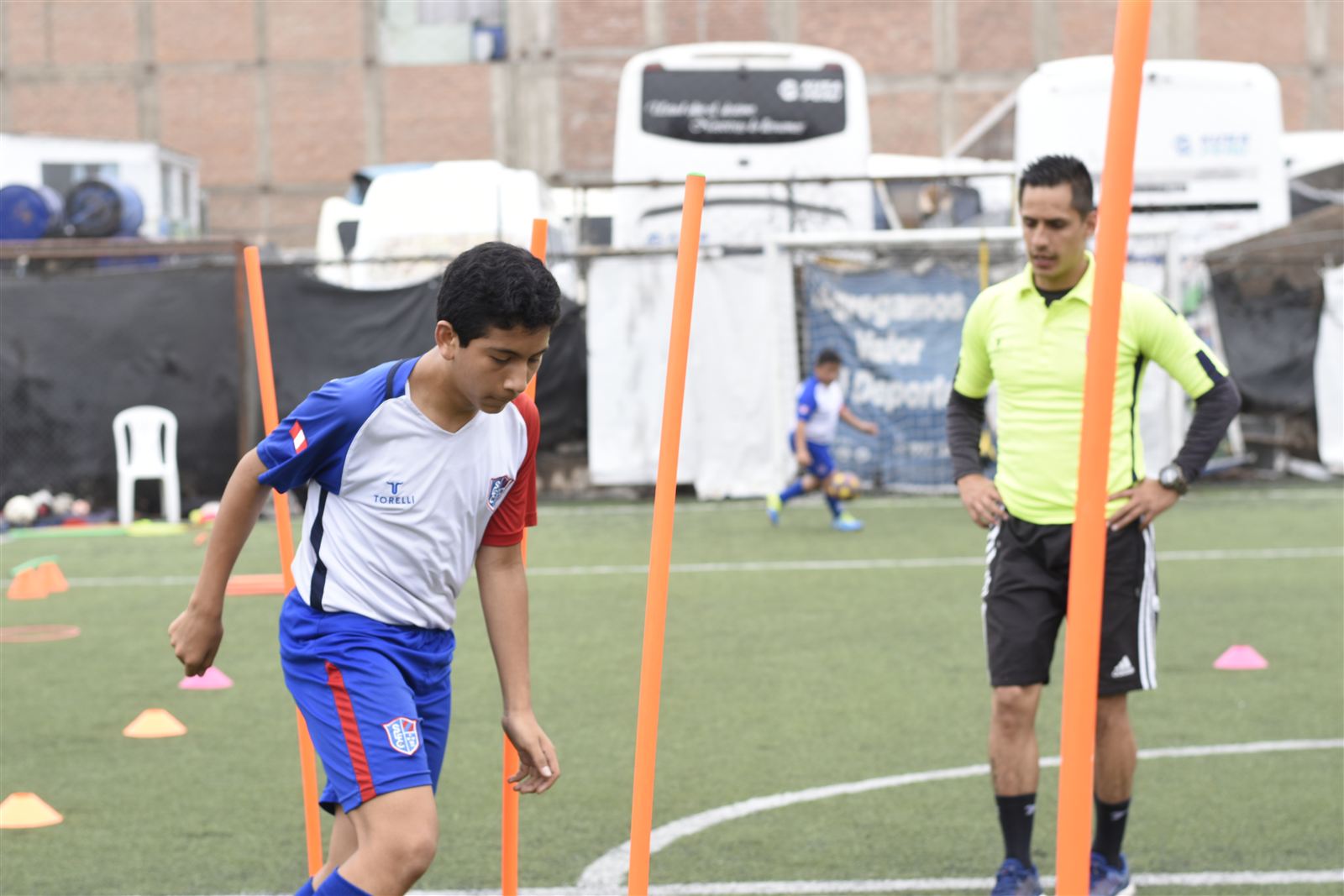 Alumno haciendo slalom entre conos con su entrenador
