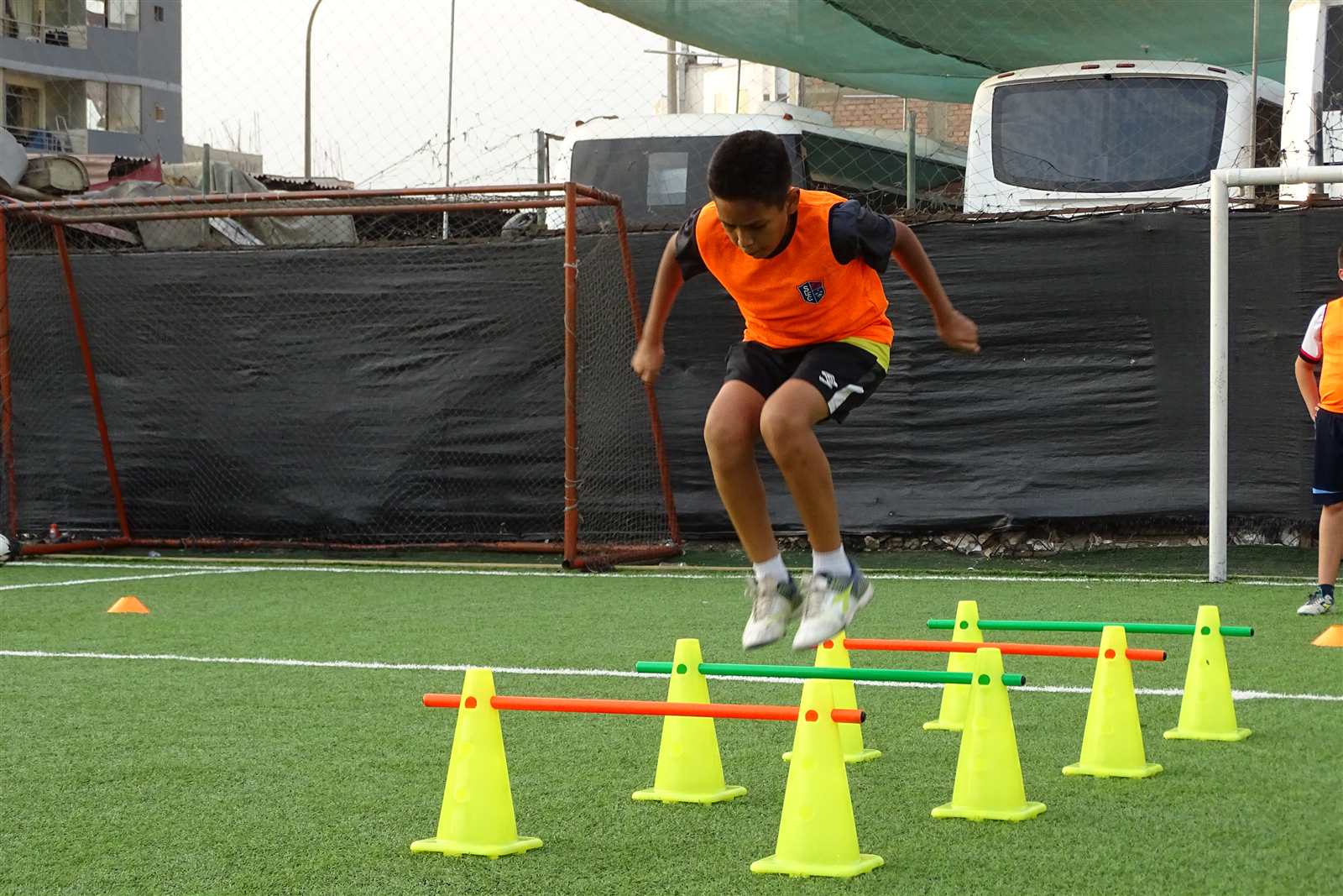 Alumno saltando vallas entre conos en un ejercicio funcional de Soccer Lima FC