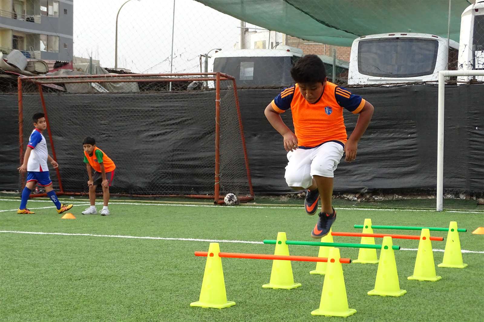 Alumno saltando vallas entre conos en un ejercicio funcional de Soccer Lima FC