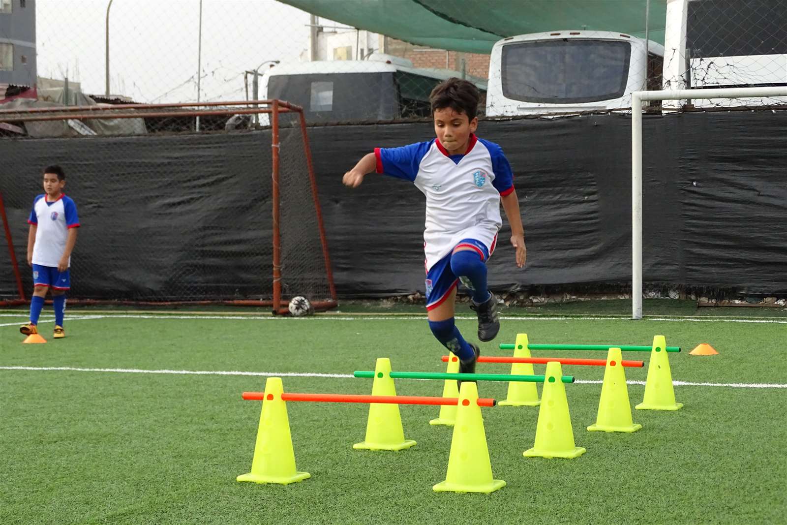 Alumno saltando vallas entre conos en un ejercicio funcional de Soccer Lima FC