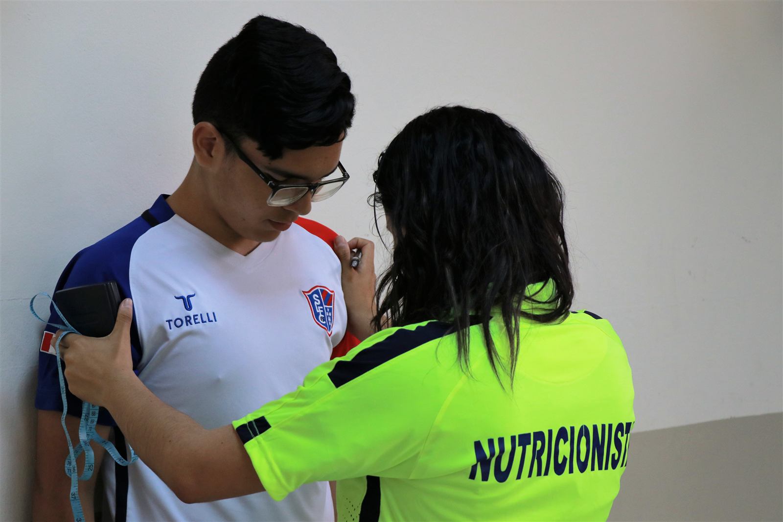Nutricionista de Soccer Lima FC midiendo a un alumno durante una evaluación nutricional